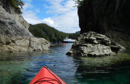 Alaska Small Ship Cruise Ship in bay with sea kayaker