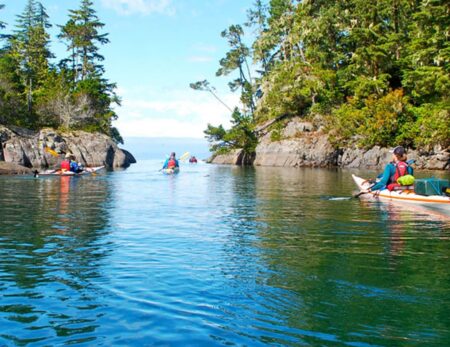 sea kayaker paddling through narrow channel in British Columbia
