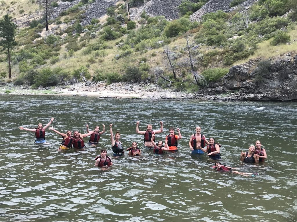 Family playing in the river during a whitewater rafting trip