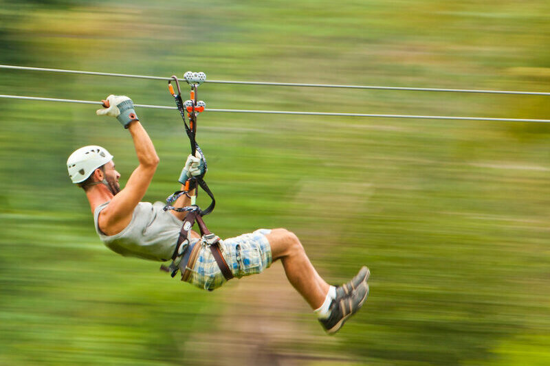 man zip lining in jungle