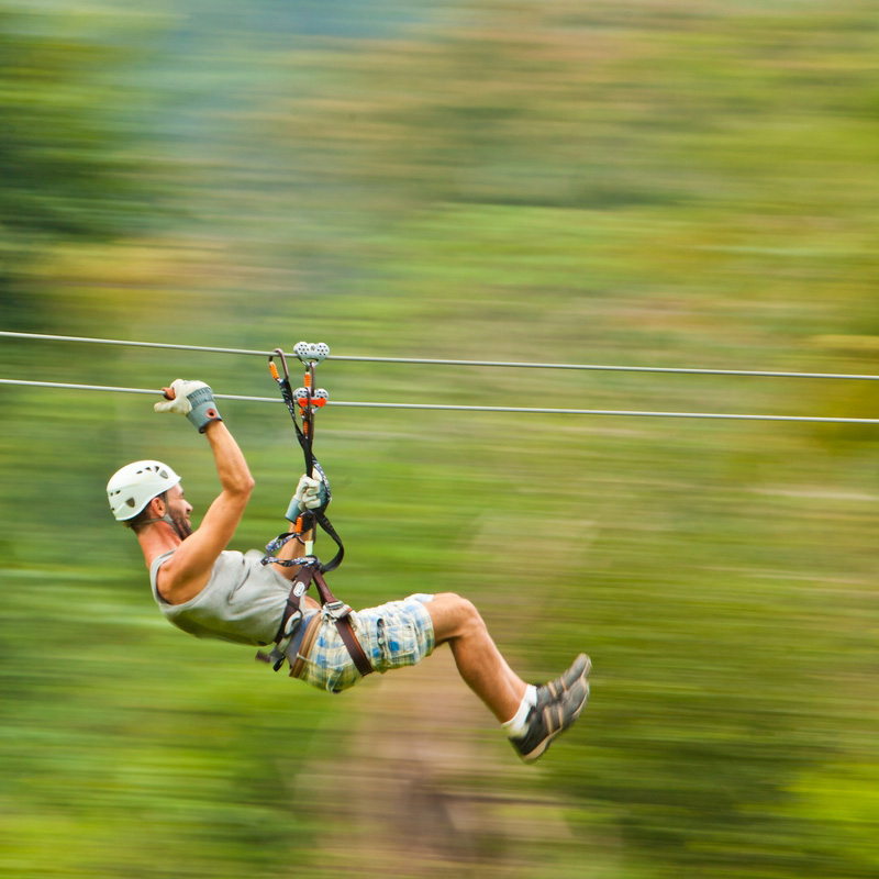 man zip lining in jungle