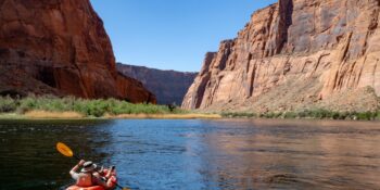 inflatable kayaker paddling the Colorado River through Horseshoe Bend