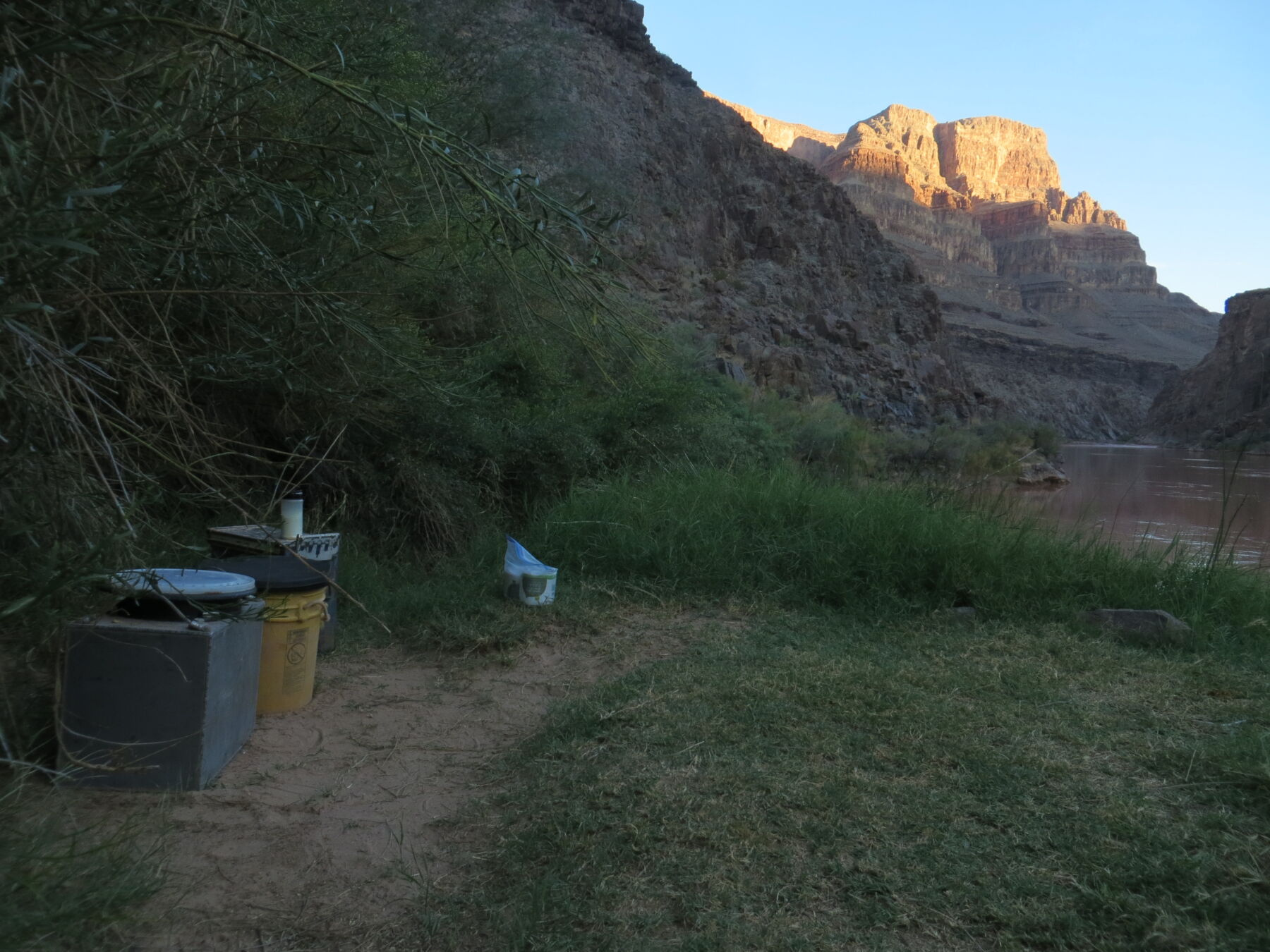 a rafting toilet with sunrise light on the canyon walls above the Colorado River
