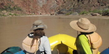 two rafters wearing sun hats and shirts