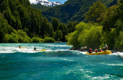 rafters running Isla Rapid on the Futaleufu River with white capped mountain in the background