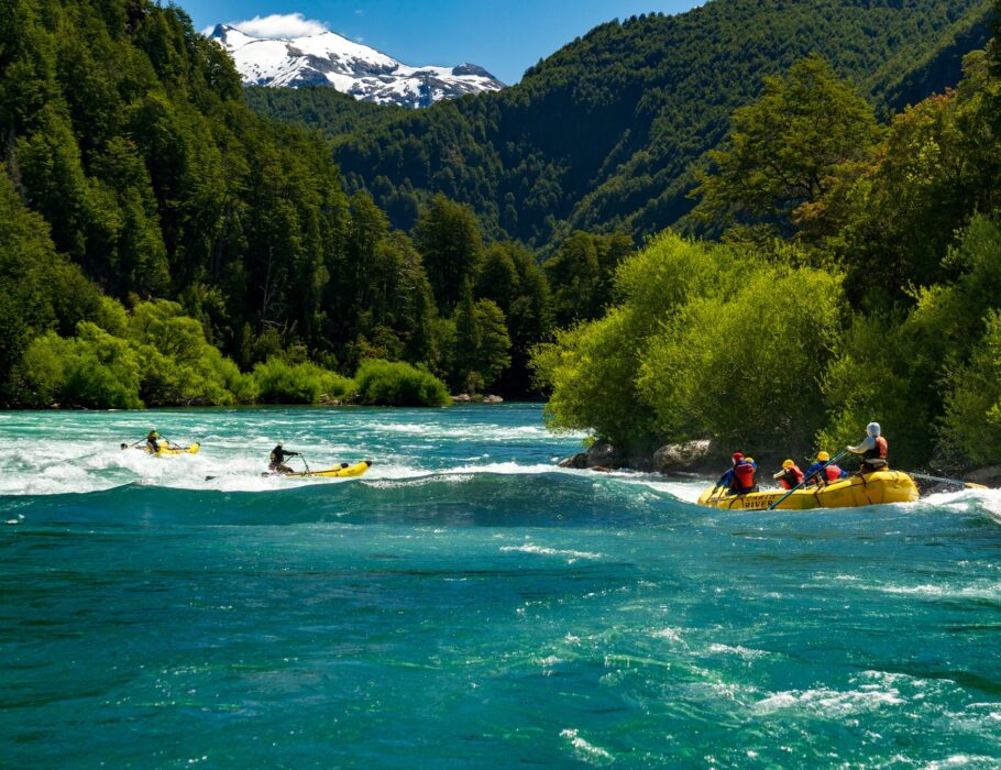 rafters running Isla Rapid on the Futaleufu River with white capped mountain in the background